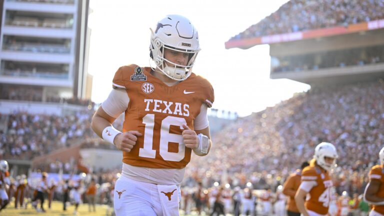 Arch Manning, wearing his number 16 jersey, jogs on the football field in 2026 as fans watch from the stands.