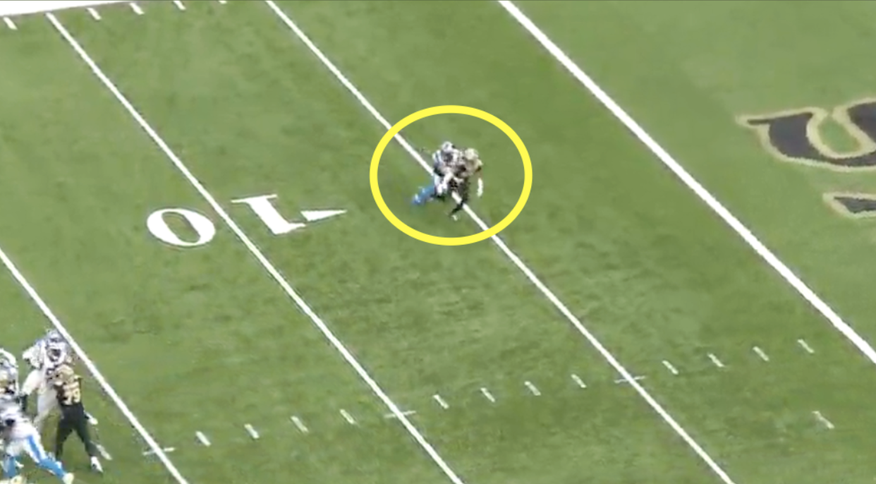 Two football players collide near the 10-yard line, with a yellow circle highlighting the pre-snap design on the field.