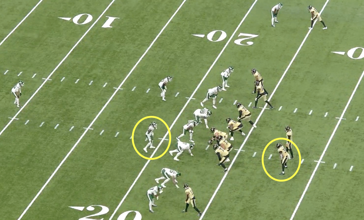 Football players line up at scrimmage as a play design highlights two opponents, including Saints' Chris Olave, in yellow circles.