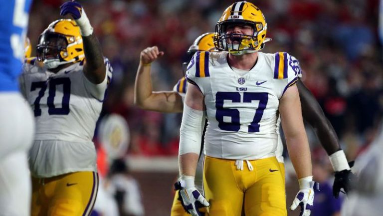 LSU player number 67, Bordelon, stands on the field with a teammate during a spring game on the offensive line.