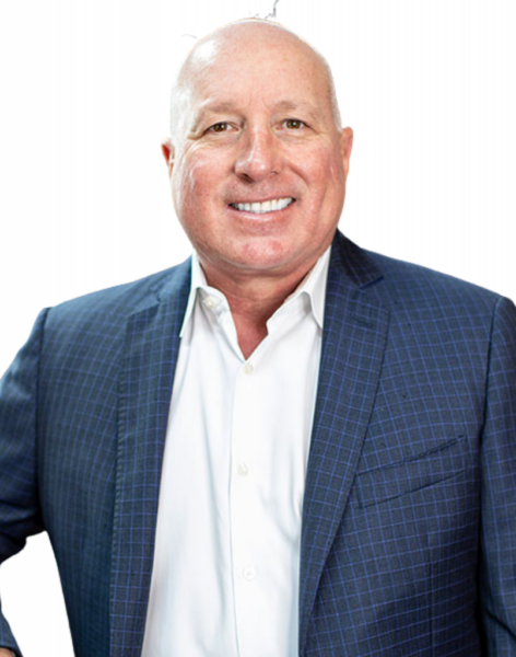 A man wearing a blue checked suit jacket and white shirt smiles at the camera in front of a plain white background.