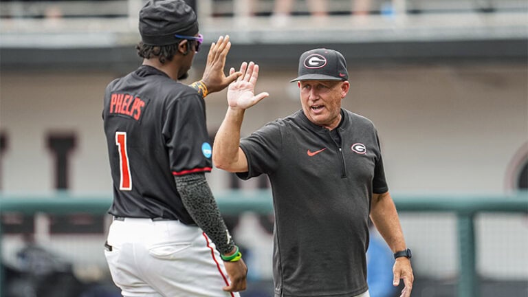 Wes Johnson and player share a high five during an NCAA Super Regionals game.