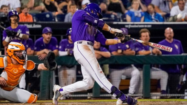 An LSU player in a purple uniform swings at a pitch as an orange-clad catcher crouches during the 2023 national title game.
