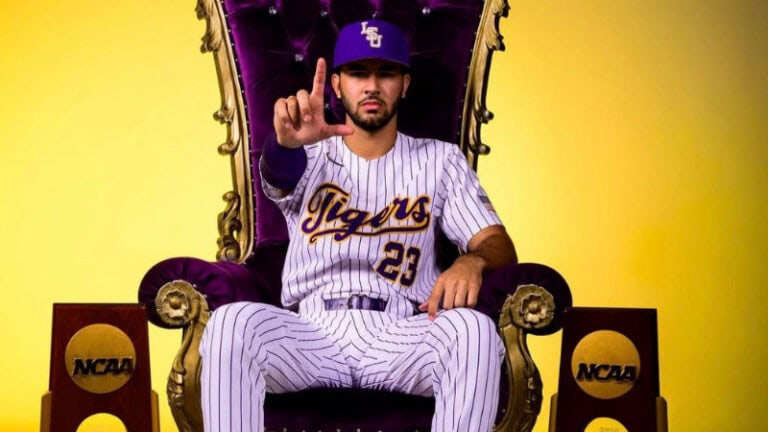 A baseball player in an LSU uniform sits on a purple and gold throne, Angel Laya style, holding up an "L" with two NCAA trophies nearby.