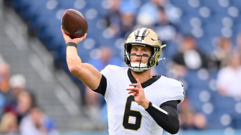A football player in a white and black uniform gets ready to throw in an empty blue stadium, with 2026 odds raising expectations.