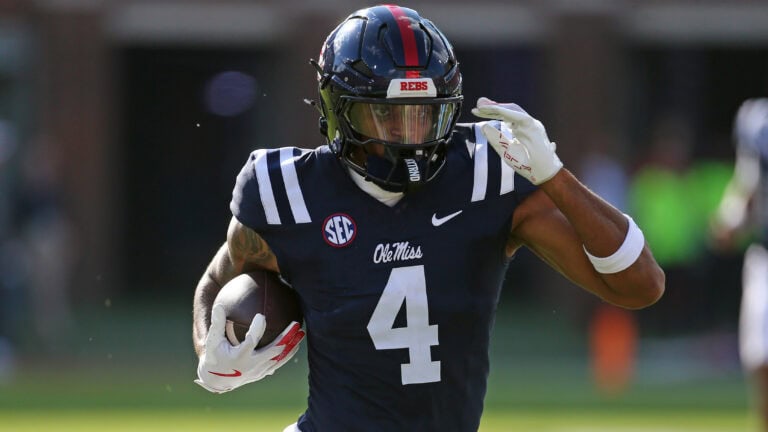An Ole Miss football player runs with the ball, focused ahead during a game against South Carolina.