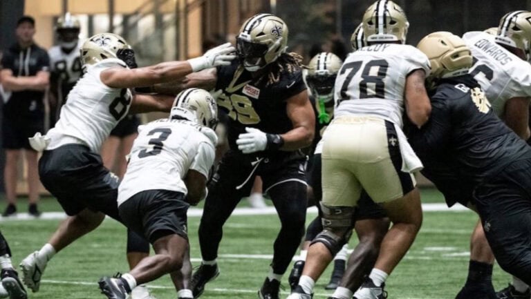 New Orleans Saints players practice defensive drills, blocking and starting strong during a team training session.
