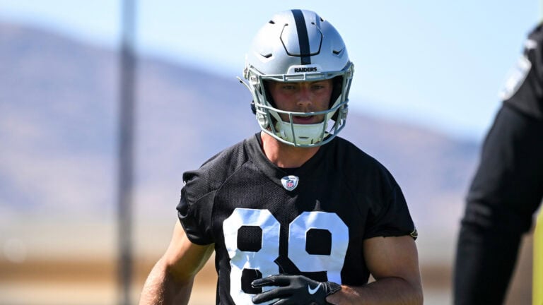 A Raiders player in a black uniform and helmet stands outside during practice, shown before the Thursday Injury Report.