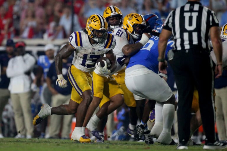 LSU’s Dilin Jones runs with the ball, dodging defenders as his teammates back him up during a heated game.