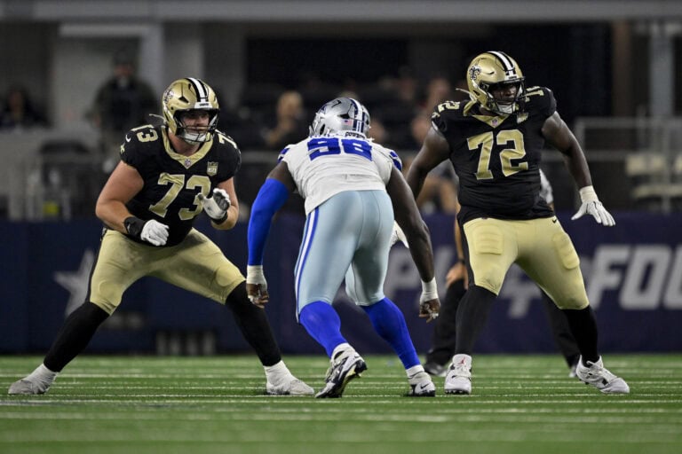 Saints players block Asim Richards of the Cowboys during an NFL game.