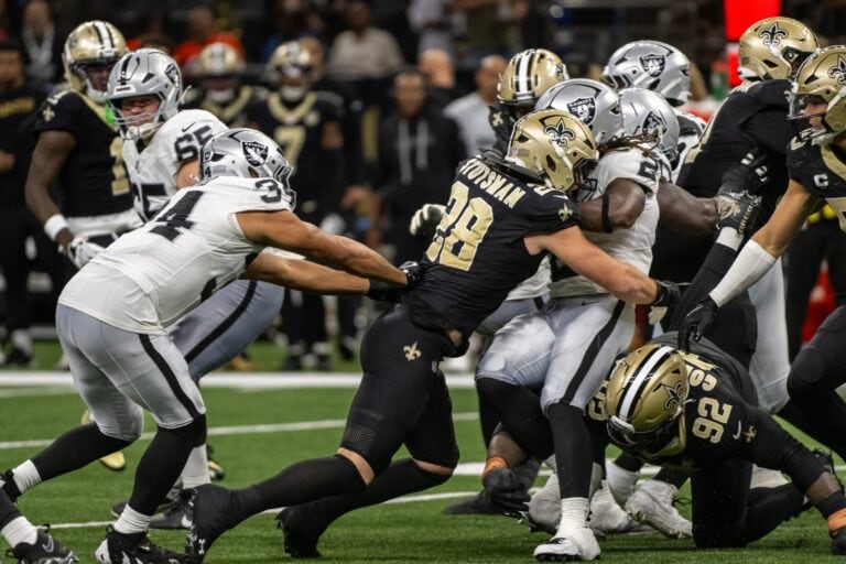 Saints defenders close in on a Raiders player, capturing an exciting moment later reviewed by Pro Football Focus.