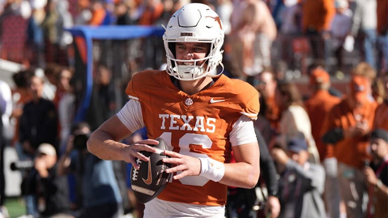 A University of Texas football player in an orange jersey and white helmet on the field.