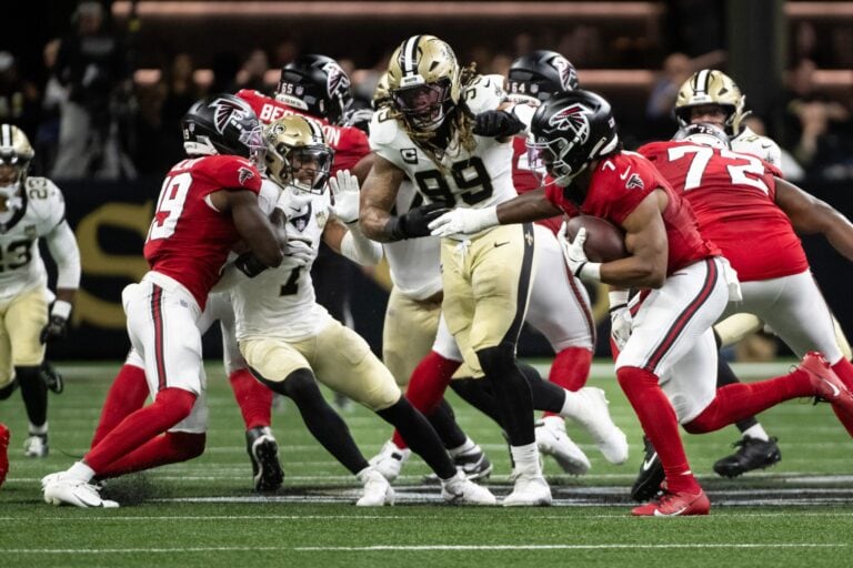 New Orleans Saints and Atlanta Falcons players collide during an NFL game.