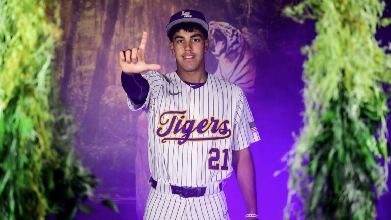 Derek Vazquez wearing a pinstriped Tigers jersey and making an L-shaped hand gesture.