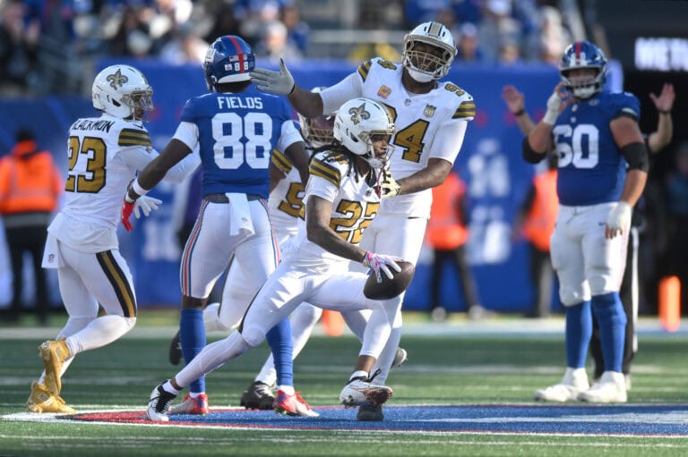 New Orleans Saints players, including Emerson Jr., maneuver against the New York Giants on a football field.