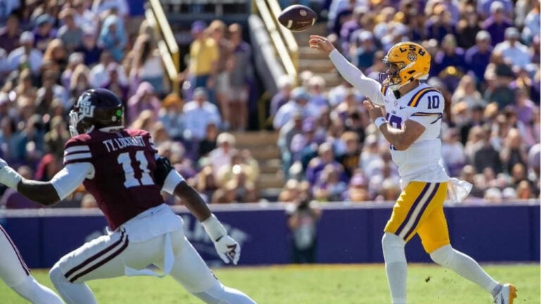 An LSU quarterback in a white uniform throws a pass as a Mississippi State defender approaches from the left.