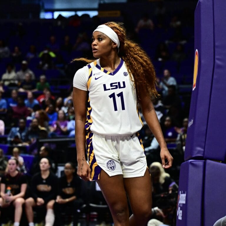 An LSU women’s basketball player in a white home jersey, wearing number 11, during a game.